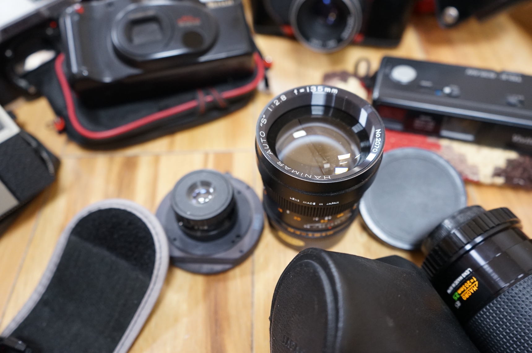 A collection of various cameras and camera equipment to include Konica